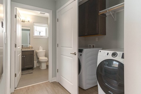 a laundry room with a washer and dryer and a bathroom with a toilet